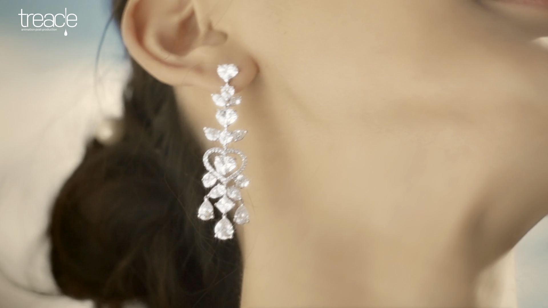 A close-up of a diamond earring worn by a bride