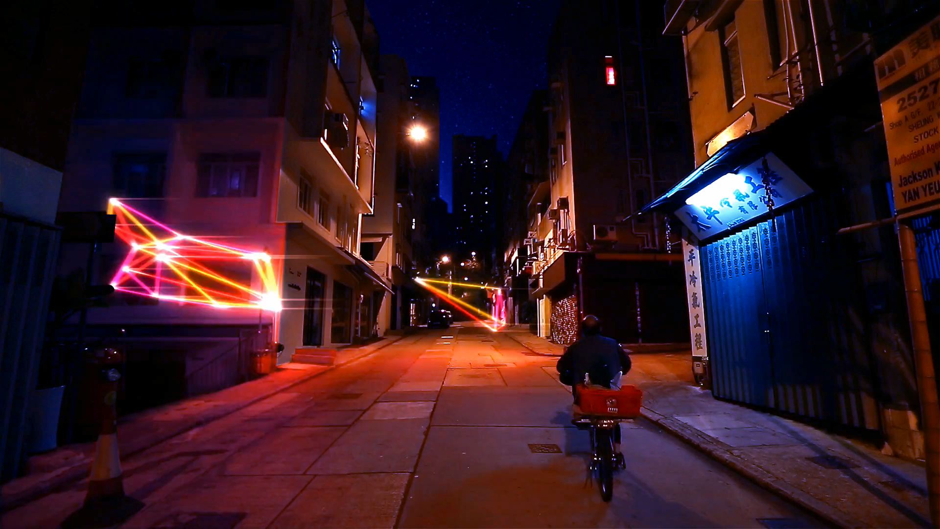 A man rides his bike through a Hong Kong street, animated shapes whiz by.