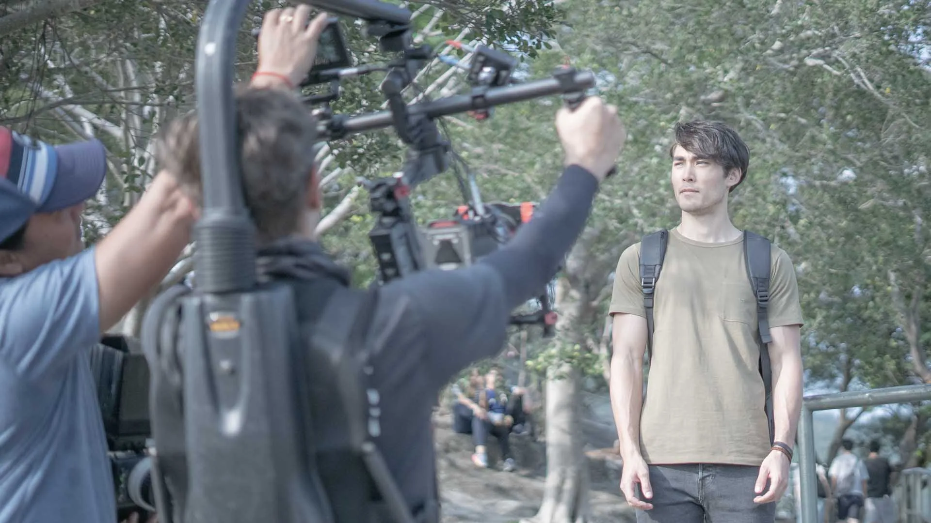 Behind the scenes shot of a cameraman using a Ronin to film a male model.