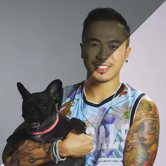 Tattoed man holding a cute Frenchie dog