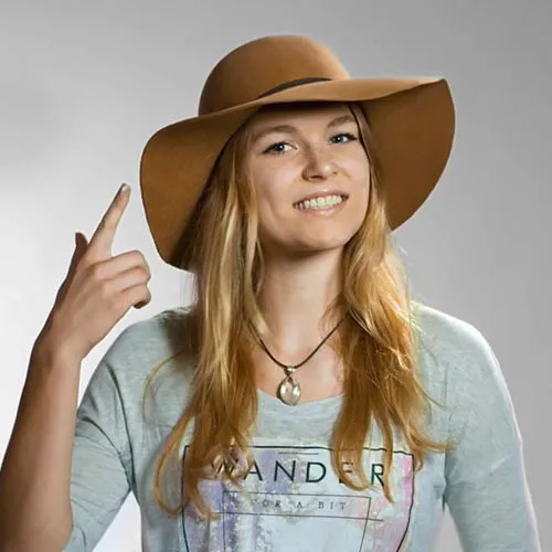 In studio shot of a yonung woman in a hat.